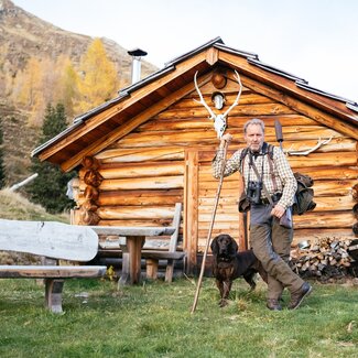 Bauer Heinz vor einer Almhütte | © Urlaub am Bauernhof Kärnten / Daniel Gollner