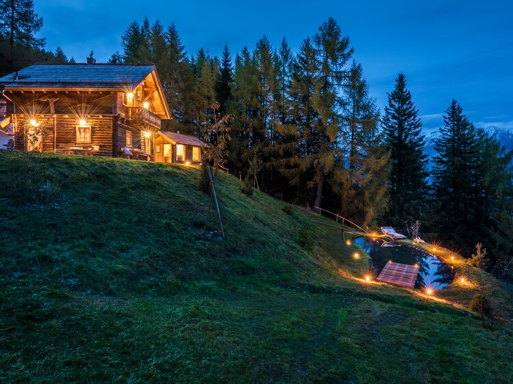 Blick auf Premiumhütte und Teich im Abendlicht  | © Günter Standl