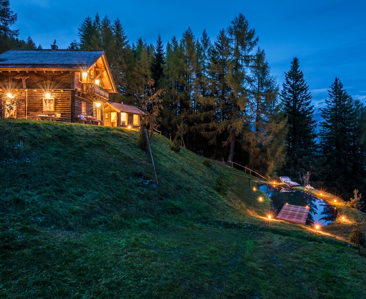 Blick auf Premiumhütte und Teich im Abendlicht  | © Günter Standl