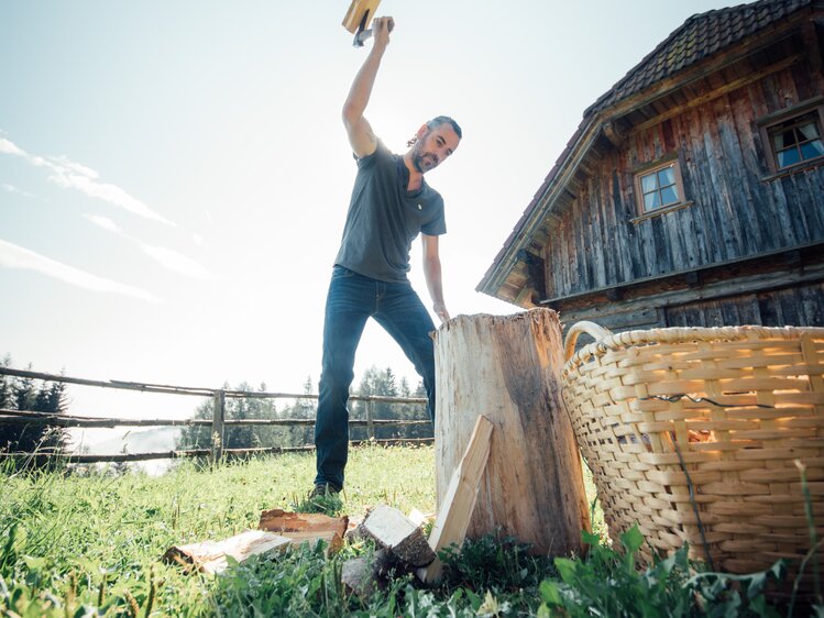 Mann hackt Holz vor der Hütte | © Urlaub am Bauernhof Steiermark / Daniel Gollner 