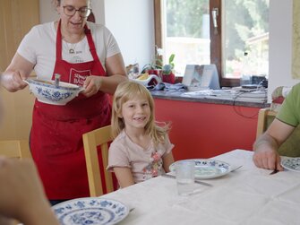 Gerlinde Weger serviert ihrer Familie das frisch gekochte Essen | © Daniel Gollner/ Urlaub am Bauernhof in Österreich