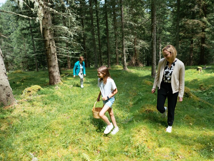 Zwei Frauen und ein  kleines Mädchen gehen im Wald Pilze sammeln. | © Urlaub am Bauernhof Kärnten/ Angelina Tschische