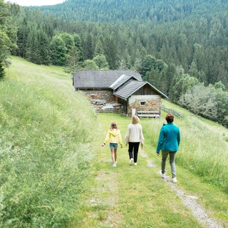 Zwei Frauen und ein Mädchen gehen den Weg hinunter zur Hütte.  | © Urlaub am Bauernhof Kärnten/ Angelina Tschische