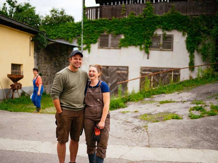 Frau und Mann umarmen sich in der Hofeinfahrt | © Urlaub am Bauernhof Kärnten / Daniel Gollner