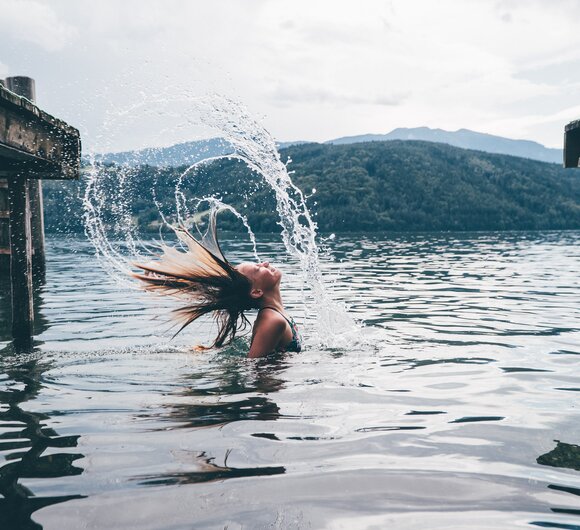 Mädchen im See spritzt das Wasser mit den Haaren | © Urlaub am Bauernhof Kärnten/ Daniel Gollner