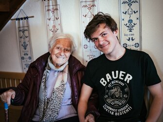 Enkel und Oma sitzen auf der Bank | © Urlaub am Bauernhof Kärnten / Daniel Gollner