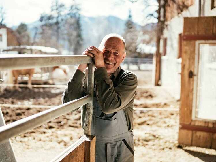 Mann steht bei Gatter | © Urlaub am Bauernhof Kärnten / Daniel Gollner