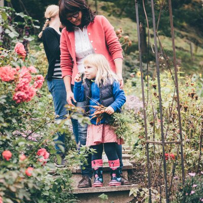 Frau und Kinder gehen durch den Garten | © Urlaub am Bauernhof Kärnten/ Daniel Gollner