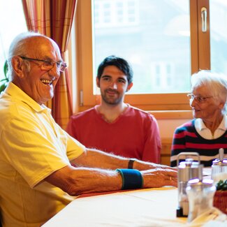 Familie sitzt am Tisch und lacht | © Urlaub am Bauernhof Kärnten / Daniel Gollner