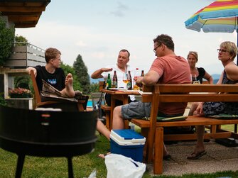 Familie sitzt gemeinsam beim Grillabend | © Urlaub am Bauernhof / Daniel Gollner