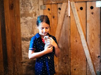 Mädchen halt den Hasen in der Hand | © Urlaub am Bauernhof Kärnten / Daniel Gollner