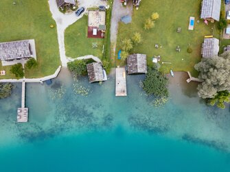 Hütten am Ufer des Sees | © Urlaub am Bauernhof Kärnten / Daniel Gollner