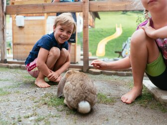 Kinder beim Hasen im Hasenstall | © Urlaub am Bauernhof Kärnten / Daniel Gollner