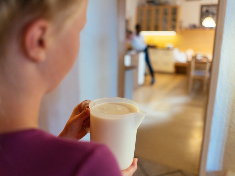 Mädchen trägt ein Gefäß mit Milch | © Urlaub am Bauernhof Kärnten / Daniel Gollner