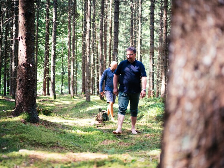 Männer gehen barfuß im Wald | © Urlaub am Bauernhof Kärnten / Daniel Gollner