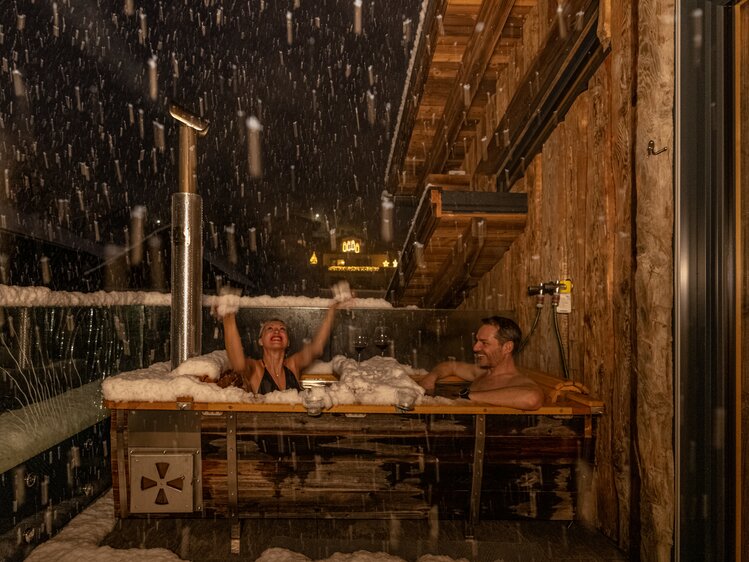 Paar badet im Holzbad auf der verschneiten Terrasse | © Urlaub am Bauernhof Kärnten/ Achim Mandler