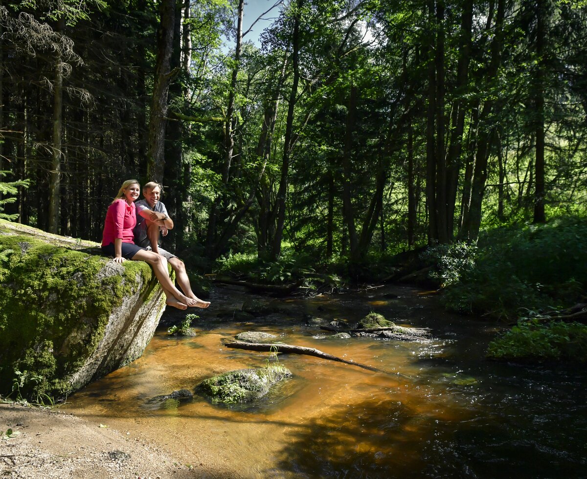 Paar sitzt auf Stein bei einem Flussbett im Waldviertel | © Waldviertel Tourismus / Robert Herbst