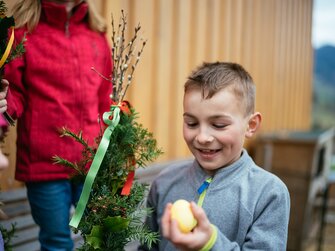 Kind mit Palmbuschen und Osterei | © Urlaub am Bauernhof Oberösterreich / Daniel Gollner