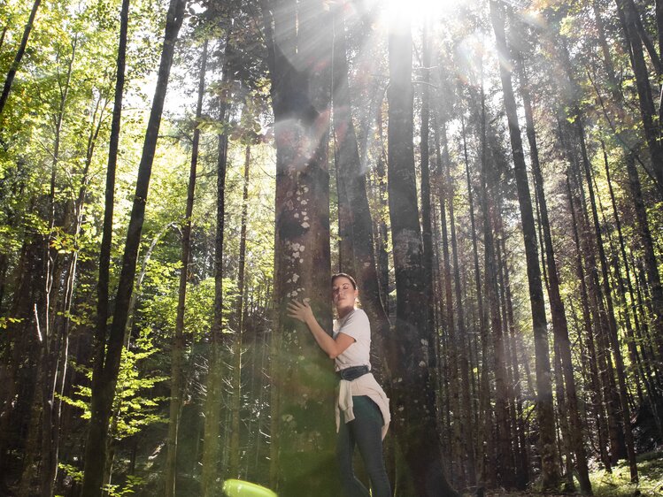 Frau lehnt beim Baum beim Waldbaden | © Urlaub am Bauernhof Oberösterreich / puremotions photography