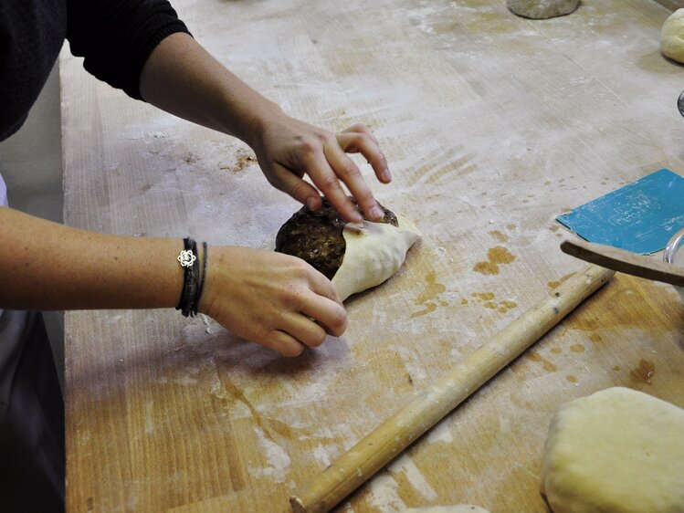 Köchin schlägt das Kletzenbrot in dünn ausgerollten Teig ein. | © Urlaub am Bauernhof Oberösterreich / Harald Puchegger