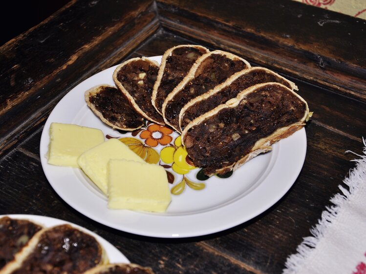 Auf dem Teller sind Scheiben frisch gebackenes Kletzenbrot mit zarter Butter angerichtet. | © Urlaub am Bauernhof Oberösterreich / Harald Puchegger