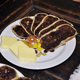 Auf dem Teller sind Scheiben frisch gebackenes Kletzenbrot mit zarter Butter angerichtet. | © Urlaub am Bauernhof Oberösterreich / Harald Puchegger