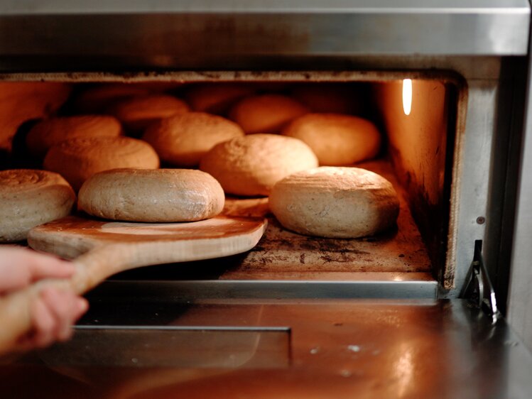 Brotlaibe werden in den Ofen eingeschossen | © Urlaub am Bauernhof Oberösterreich / Daniel Gollner