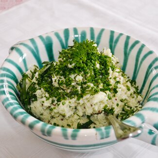 Eine Schüssel aus Gmundner Keramik mit einer Portion Mühlviertler Leinölerdäpfel | © Urlaub am Bauernhof Oberösterreich / Harald Puchegger