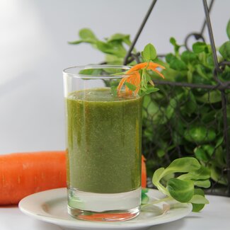 Karotten-Spinat-Smoothie im Glas mit einer Dekoration aus frischem Feldsalat und Karotten | © Urlaub am Bauernhof Oberösterreich