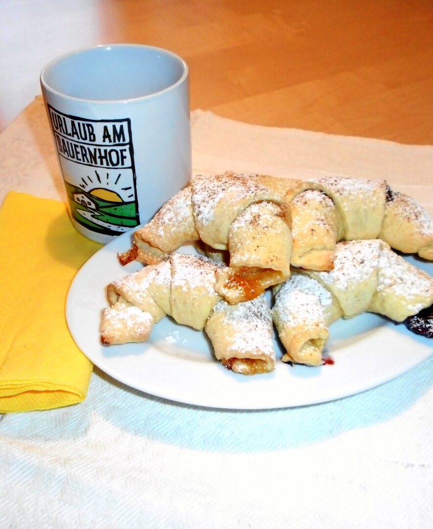 Ein Teller mit süßen Erdäpfelkipferln und einer Urlaub am Bauernhof-Tasse | © Urlaub am Bauernhof Oberösterreich / Helga Kitzmüller