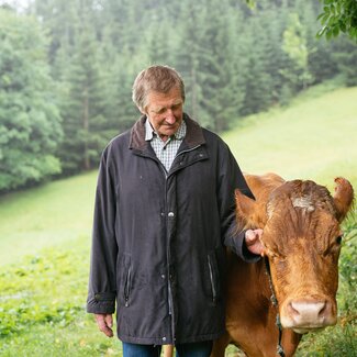 Der Gastgeber vom Bauernhof Morgenbesser bei den Kühen | © Daniel Gollner / Urlaub am Bauernhof