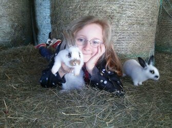 Mädchen mit 2 Hasen im Heu | © Urlaub am Bauernhof Österreich / Kerndler 