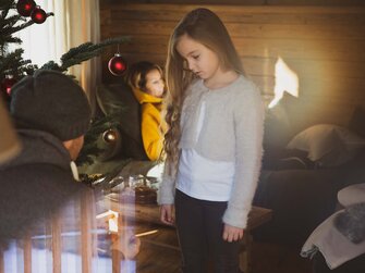 Mädchen steht vor Christbaum im Wohnzimmer | © Urlaub am Bauernhof / Pascal Baronit