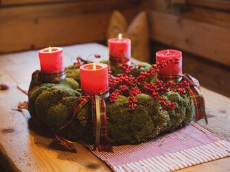 Adventkranz mit drei brennenden Kerzen in einer Bauernstube | © Urlaub am Bauernhof / Pascal Baronit