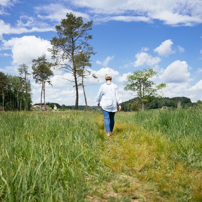 Frau geht durch Wiese in Moor | © Daniel Gollner / Urlaub am Bauernhof