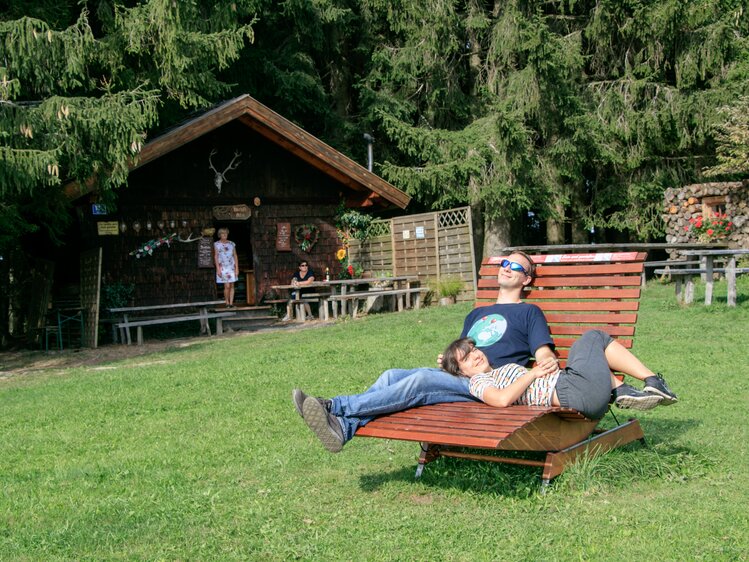 Ein Paar entspannt auf einer Sonnenliege vor der Dichtlalm in Neumarkt am Wallersee. | © Urlaub am Bauernhof im SalzburgerLand / www.travelpins.at