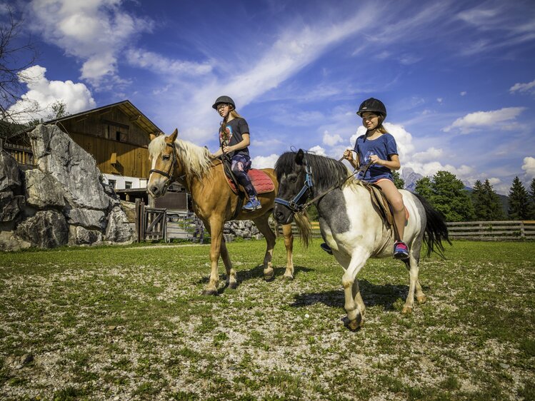 Zwei Mädchen reiten am Berghof-Pension Wildau in St. Martin am Tennengebirge im SalzburgerLand. | © Urlaub am Bauernhof / Bernd Suppan