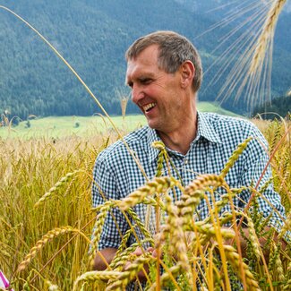 Bauer im Getreidefeld mit Getreide, Zieferhof in Leogang, Salzburger Land | © Urlaub am Bauernhof / Matthias Gruber