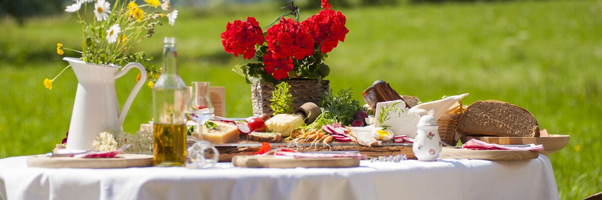 Gedeckter Tisch mit regionalen Produkten vom Bauernhof | © Urlaub am Bauernhof / punkt&komma Gedeckter Tisch mit regionalen Produkten vom Bauernhof im Freien | © Urlaub am Bauernhof / punkt&komma