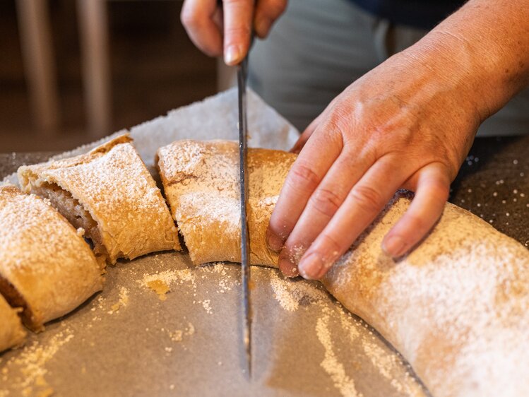 Der frisch gebackene Strudel wird aufgeschnitten  | © Urlaub am Bauernhof / Punkt & Komma