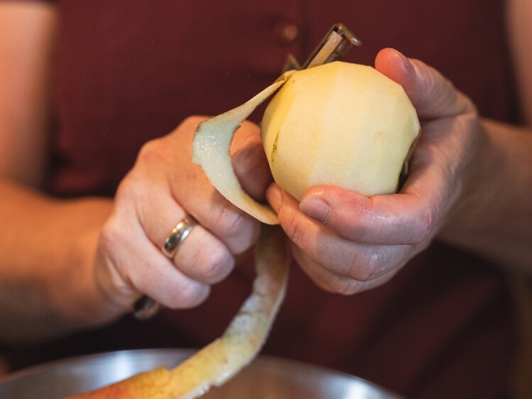 Bäuerin beim Apfelschälen für den Apfelstrudel, Steiermark | © Urlaub am Bauernhof / Punkt & Komma