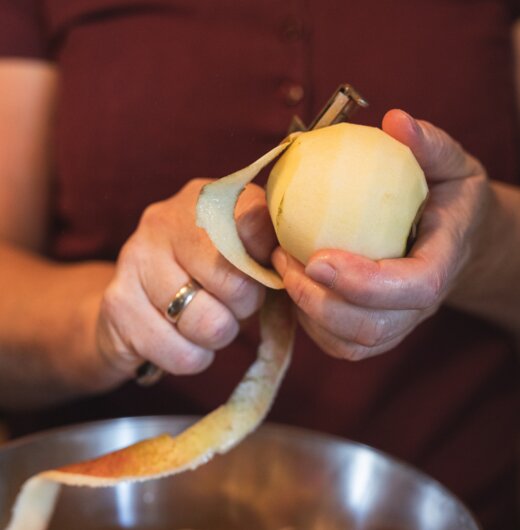 Bäuerin beim Apfelschälen für den Apfelstrudel, Steiermark | © Urlaub am Bauernhof / Punkt & Komma