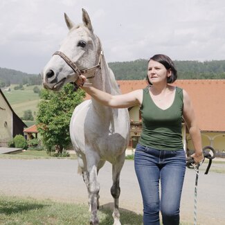 Bäuerin führt ihr Pferd über den Hof, Forstbauer, Steiermark | © Urlaub am Bauernhof Steiermark / Daniel Gollner