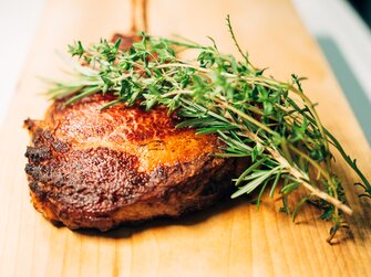 Appetitliches Steak mit Rosmarinzweig am Holzbrett, Lurgbauer, Steiermark | © Urlaub am Bauernhof Steiermark / Daniel Gollner