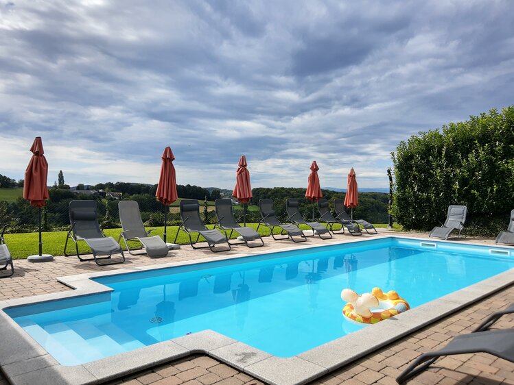 Pool mit Liegestühlen im Hintergrund, Schwalbenhof, Steiermark | © Urlaub am Bauernhof Steiermark / Evelyn Götz