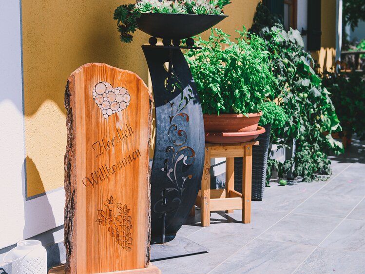 Herzlich Willkommen Schild und verschieden Topfpflanzen vor dem Haus | © Urlaub am Bauernhof Steiermark / Sabine Ertl