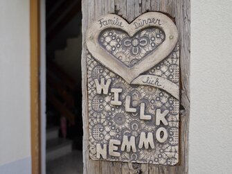 Ton Schild mit dem Schirftzug Herzlich Willkommen  | © Urlaub am Bauernhof | Daniel Gollner 