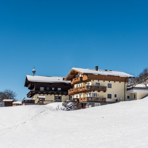 Der Bauernhof im Winter, mit schneebedeckten Dächern und Balkonen in der verschneiten Landschaft. Der Bauernhof im Winter, mit schneebedeckten Dächern und Balkonen in der verschneiten Landschaft.