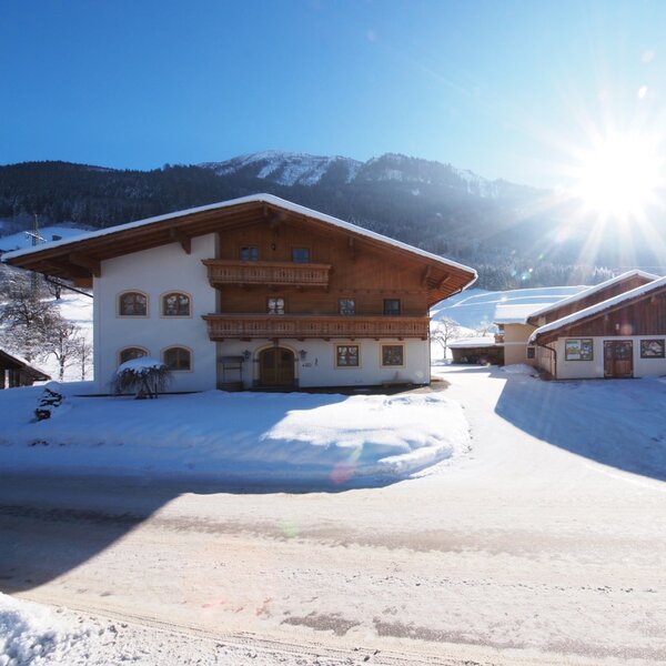 Die Außenansicht des Bauernhofs in einer verschneiten Berglandschaft bei Sonnenschein. Die Außenansicht des Bauernhofs in einer verschneiten Berglandschaft bei Sonnenschein.
